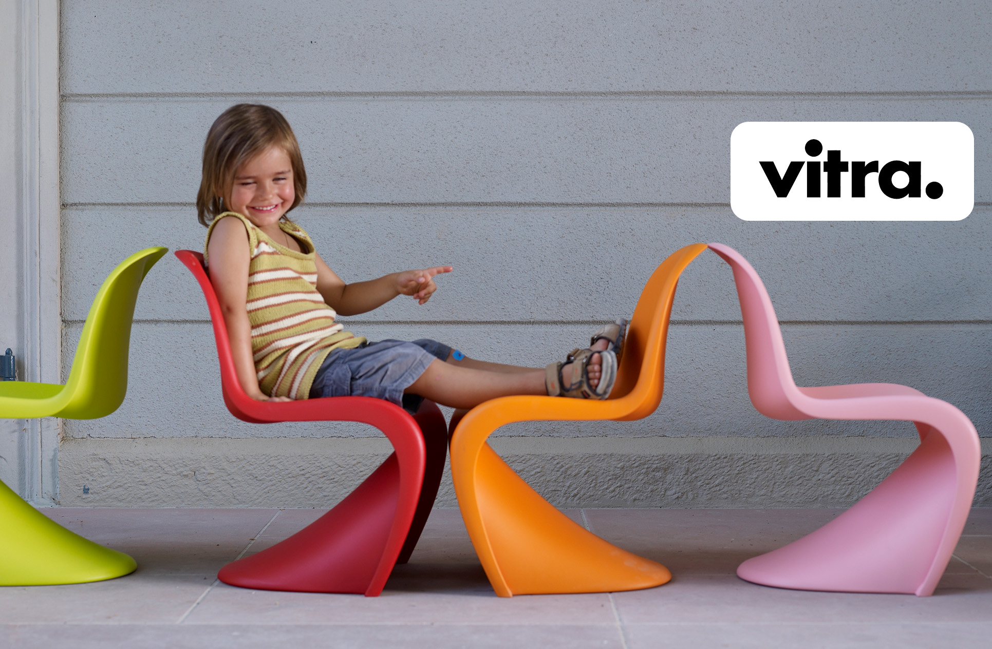 Ein Kleinkind sitz auf dem Stuhl Panton Junior von Vitra. 