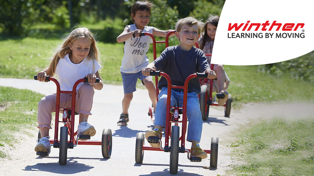 Vier Kinder auf unterschiedlichen Fahrgeräten, fahren einen Weg entlang. In der oberen rechten Ecke ist das Winther Logo zu sehen.