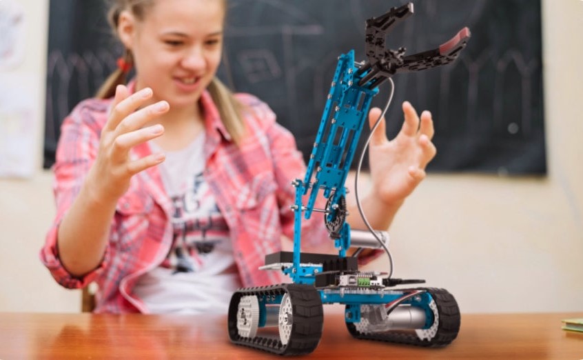 Mädchen spielt mit dem makeblock Lernroboter mit Greifarm