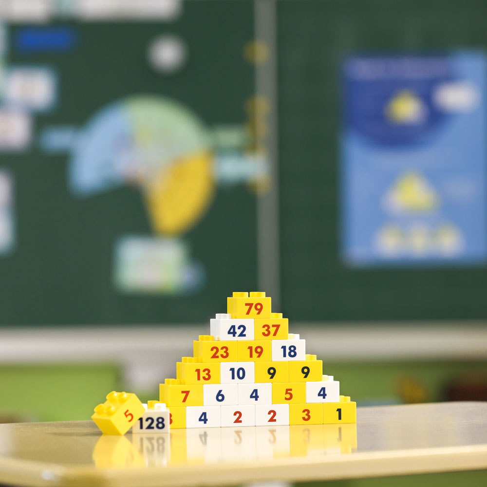 Hubelino Zahlenmauer Lernspiel als Pyramide auf einem Schülertisch aufgebaut