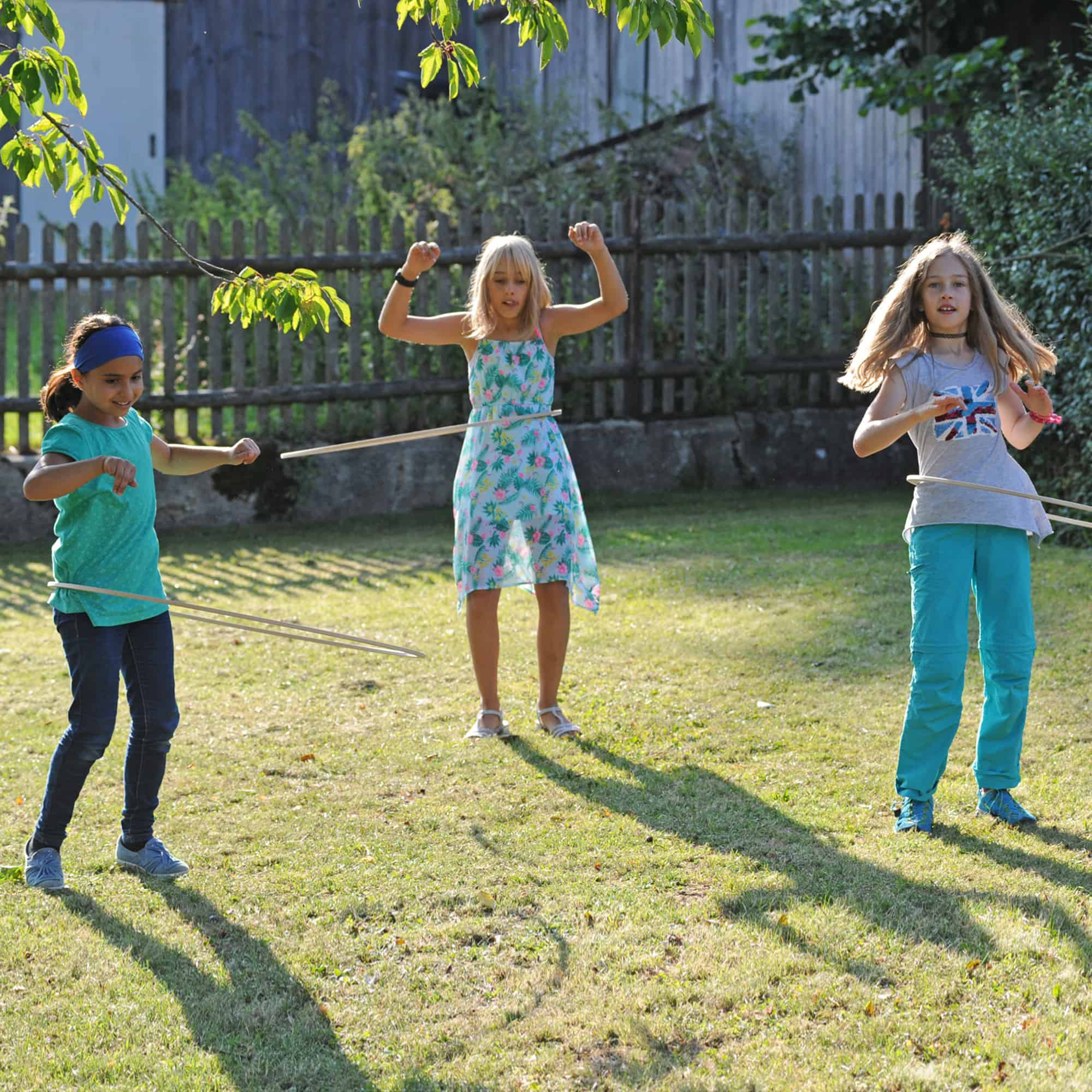 Kinder spielen mit Pedalo Bewegungsspiel im Garten